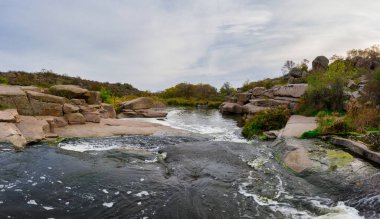 Ukrayna 'da akşam ışığında vahşi doğada küçük hızlı bir şelale Kamenka..