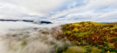 Gökyüzü beyaz ve kabarık bulutlar ile yeşil sonbahar tepeleri üzerinde, hava panoramik drone çekim