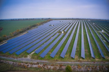 Ukrayna 'daki pitoresk yeşil bir alanda güneş enerjisini kullanmak için devasa bir güneş enerjisi santrali. Hava panoramik İHA görüntüsü