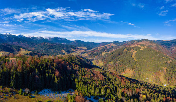 Picturesque mountain landscapes of autumn with snow near the village of Dzembronya in Ukraine Carpathians mountains.