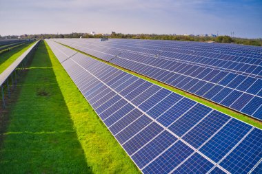 Ukrayna 'daki pitoresk yeşil bir alanda güneş enerjisini kullanmak için devasa bir güneş enerjisi santrali. Hava panoramik İHA görüntüsü