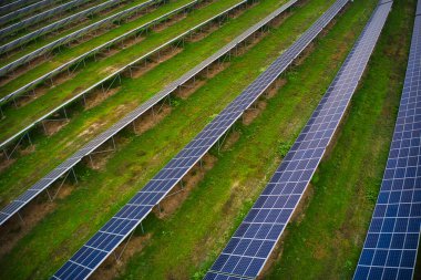 Ukrayna 'daki pitoresk yeşil bir alanda güneş enerjisini kullanmak için devasa bir güneş enerjisi santrali. Hava panoramik İHA görüntüsü