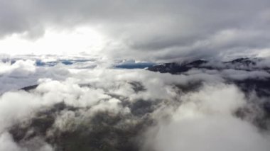 Mavi gökyüzünde uçmak Dağların üzerinde bulutlarla