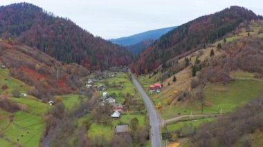 Ukrayna 'daki Karpat Dağları' nda bir dağ geçidinde yol boyunca küçük bir köy.