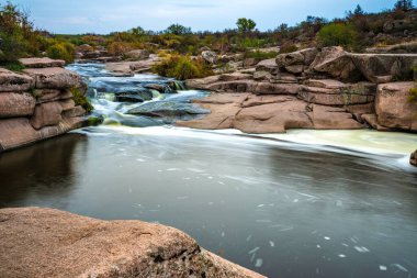 Ukrayna 'nın pitoresk doğası üzerine serin bir sonbaharda, sararmış altın otlarla kaplı beyaz ıslak taşların arasında fantastik bir dere akıyor.