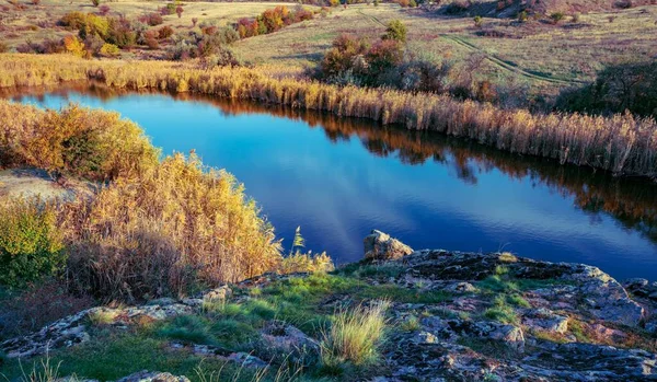 ウクライナの丘の上に大きな白い石と緑の植生の中で輝く美しい小さな川 — ストック写真