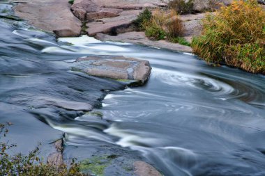 Ukrayna 'nın pitoresk doğası üzerine serin bir sonbaharda, sararmış altın otlarla kaplı beyaz ıslak taşların arasında fantastik bir dere akıyor.