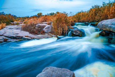 Ukrayna 'nın pitoresk doğası üzerine serin bir sonbaharda, sararmış altın otlarla kaplı beyaz ıslak taşların arasında fantastik bir dere akıyor.