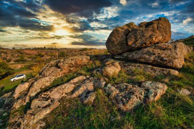 Büyük yeşil-sarı bir tarlada küçük bir taş yığını olağanüstü güzel mavi bir gökyüzünün arka planına karşı.