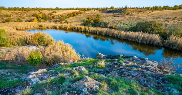 ウクライナの丘の上に大きな白い石と緑の植生の中で輝く美しい小さな川 — ストック写真