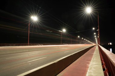 Dnepropetrovsk, Ukrayna 'daki büyük güzel Dinyeper nehri üzerinde soğuk ışıklar ve hızlı arabalarla güzel, uzun bir köprü manzarası.