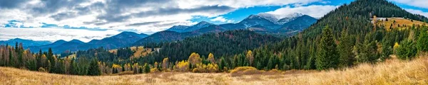 美丽的五彩斑斓的森林覆盖着喀尔巴阡山脉和一个小村子 背景是温暖的秋天的天空 — 图库照片
