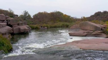 Yumuşak, karanlık ve ıslak taşların arasında hızlı bir dere.
