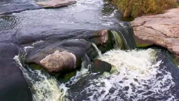 Szybki strumień wśród gładkich ciemnych i mokrych kamieni — Wideo stockowe