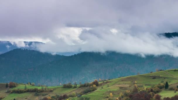 Landschappen van groene heuvels onder een laag witte en pluizige wolken — Stockvideo