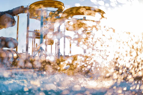 Una mujer descendió de un tobogán a una piscina con agua transparente — Foto de Stock