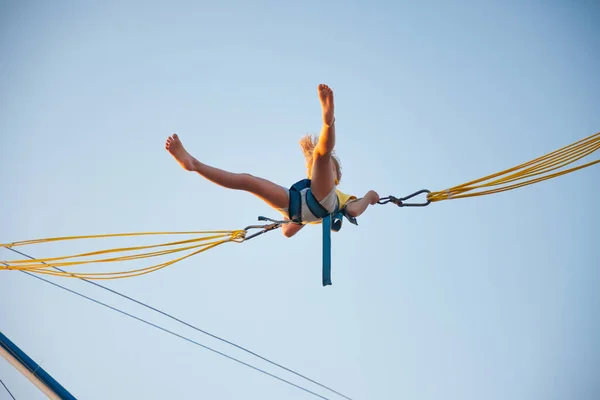Petite fille vole sur des bandes élastiques et saute sur un trampoline — Photo