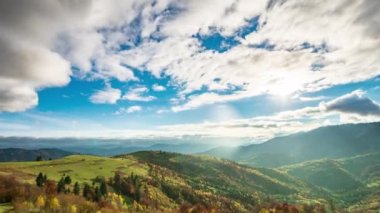 Dağların tepesinde bulutlarla mavi gökyüzünün zaman atlaması