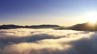 Dağın tepesinde gün doğumu gri sisle kaplı, Hava UHD 4K İHA gerçek zamanlı video, 10bit HLG ile çekildi ve renklendirildi