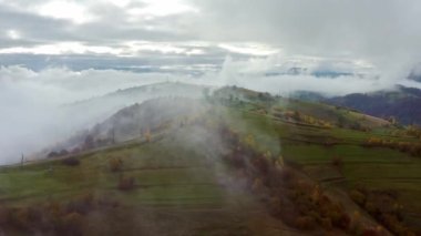 Gökyüzü beyaz ve kabarık bulutlarla yeşil sonbahar tepeleri üzerinde, Aerial UHD 4K gerçek zamanlı video, 10bit HLG ile çekildi ve renklendirildi