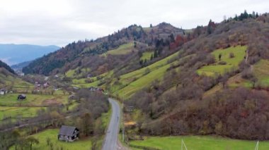 Ukrayna 'daki Karpat Dağları' nda bir dağ geçidinde yol boyunca küçük bir köy.