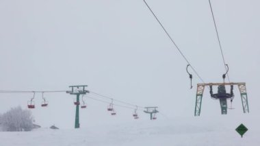 Karpatlar 'da bir dağ ormanı ve gri gökyüzünün arka planında kayak kaldırışı görüntüsü