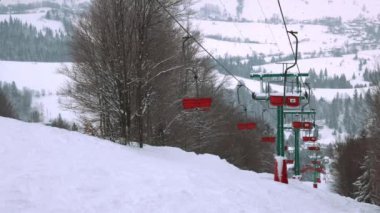 Karpatlar 'da bir dağ ormanı ve gri gökyüzünün arka planında kayak kaldırışı görüntüsü