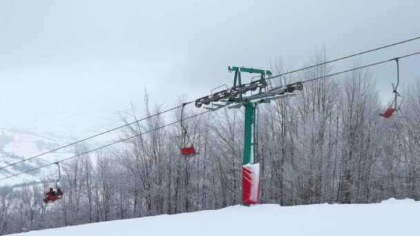 Utsikt över skidliften mot bakgrund av en fjällskog och grå himmel i Karpaterna — Stockvideo