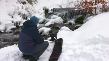 Bir adam Karpatlar 'daki bir dağ deresini yakalamak için sürgülü kamera kullanıyor.
