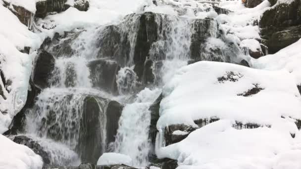 Małe strumienie zimnej wody wśród kamieni pokrytych śniegiem — Wideo stockowe