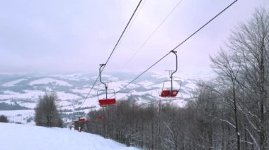 Karpatlar 'da bir dağ ormanı ve gri gökyüzünün arka planında kayak kaldırışı görüntüsü