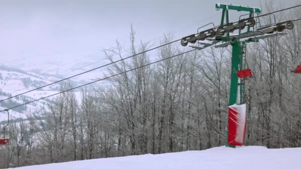 Uitzicht op de skilift tegen de achtergrond van een bergbos en grijze lucht in de Karpaten — Stockvideo