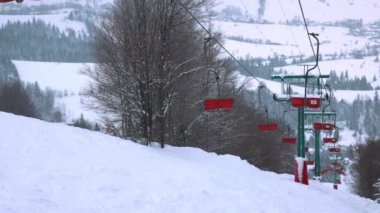 Karpatlar 'da bir dağ ormanı ve gri gökyüzünün arka planında kayak kaldırışı görüntüsü