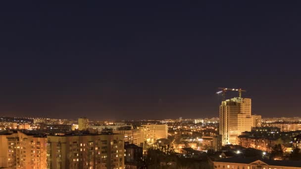 Paisaje urbano nocturno y grandes grúas torre construyen edificios de varios pisos — Vídeos de Stock