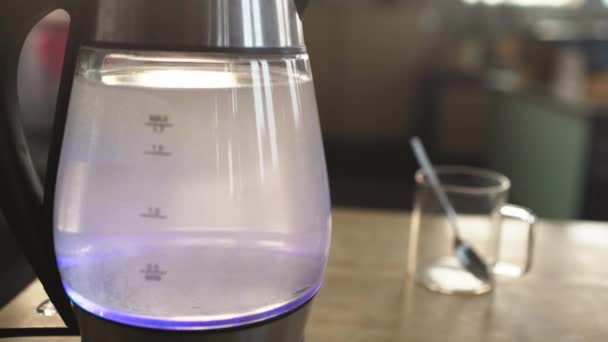 Slider shot of a transparent kettle with water boils — Stock Video