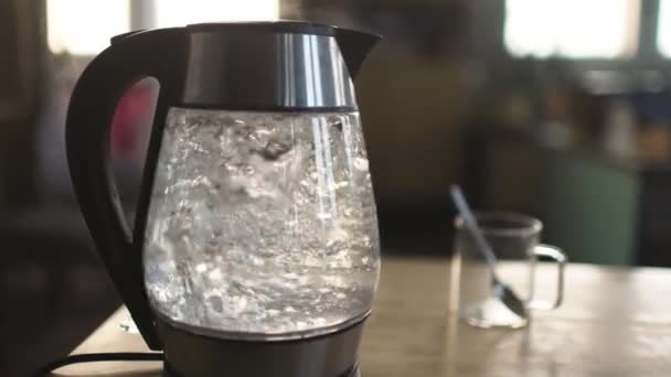 Slider shot of a transparent kettle with water boils — Stock Video
