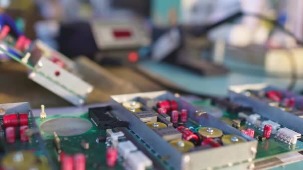 Slider shot van een connector component en groot groen microcircuit in werkplaats laboratorium — Stockvideo