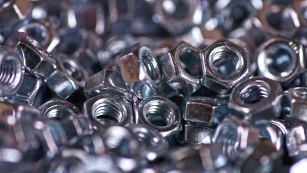 Tornillos de metal caen perfectamente en un montón de otras tuercas — Vídeos de Stock