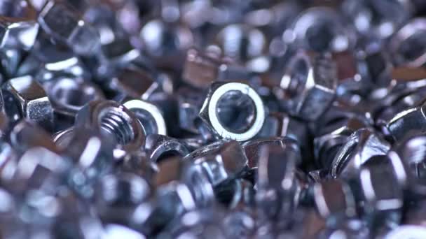 Tornillos de metal caen perfectamente en un montón de otras tuercas — Vídeos de Stock