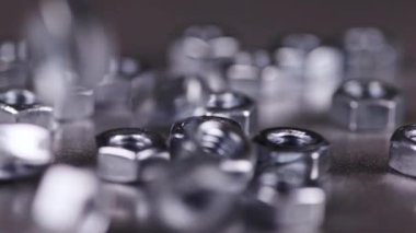 Birkaç fındık yavaşça metal kaplı çalışma masasına düşüyor.