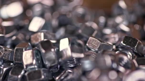 Tornillos de metal caen perfectamente en un montón de otras tuercas — Vídeo de stock