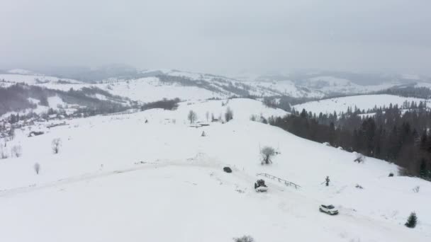 De trekker verwijdert sneeuw van de besneeuwde weg zodat de auto 's kunnen passeren — Stockvideo