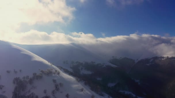 Niezwykła górska dolina pokryta puszystymi chmurami w zimowy zachód słońca — Wideo stockowe
