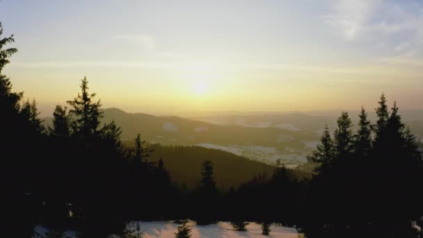 En extraordinär dal med kullar och berg täckta med gran skogar mot bakgrund av en ljus brinnande solnedgång — Stockvideo