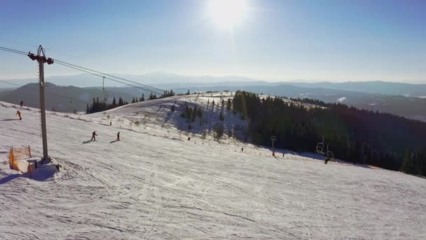 Gammel skistation på en snedækket bjergskråning med mange mennesker på ski og snowboards – Stock-video