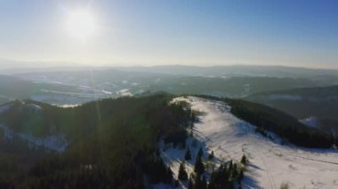 Yoğun ormanlar yüksek dağları, Karpatlar 'daki yamaçlarını ve gün batımına doğru batan parlak güneşi kaplar.