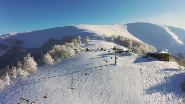 Estação de esqui velha em uma encosta de montanha nevada com um monte de pessoas em esquis e snowboards — Vídeo de Stock