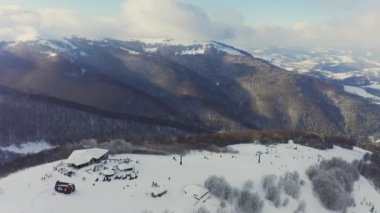 Karlı bir dağ yamacında eski bir kayak istasyonu Kayak ve snowboard yapan bir sürü insan var