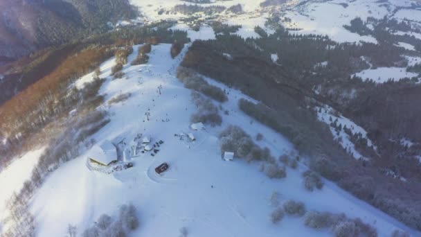 Estação de esqui velha em uma encosta de montanha nevada com um monte de pessoas em esquis e snowboards — Vídeo de Stock