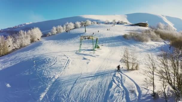 Karlı bir dağ yamacında eski bir kayak istasyonu Kayak ve snowboard yapan bir sürü insan var — Stok video